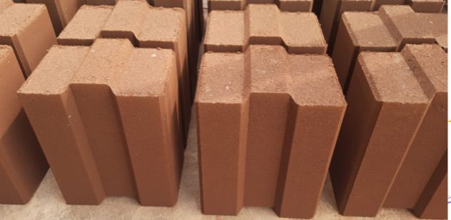 Neatly stacked red interlocking bricks showing the tongue-and-groove profile